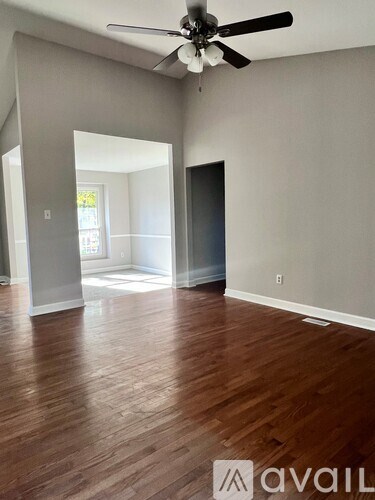 A room with wooden floors and a ceiling fan.