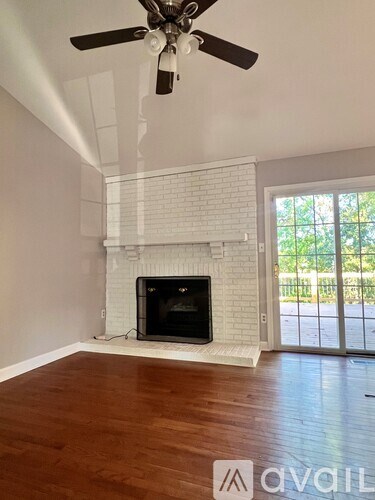 A room with a fireplace and a ceiling fan.