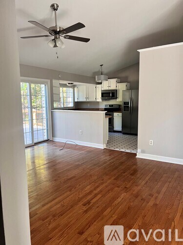 A room with wooden floors and a ceiling fan.