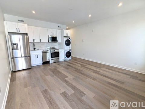 A kitchen with a refrigerator, oven, and microwave.