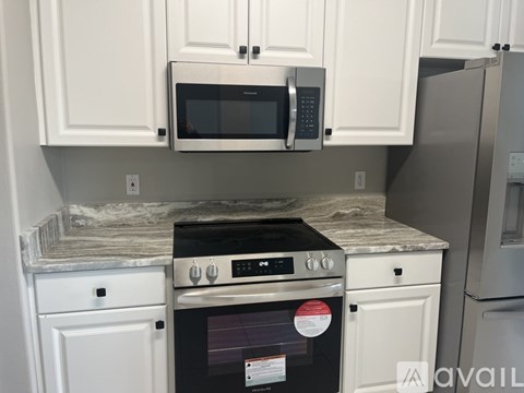 A kitchen with white cabinets and a black oven.