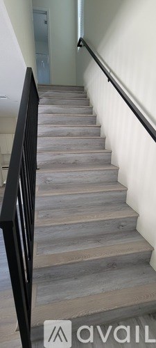 A staircase with a black railing and wooden steps.