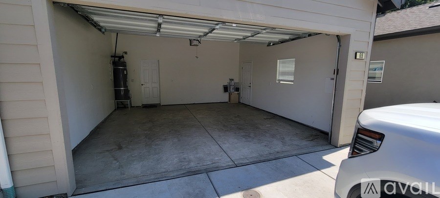 A garage with a white car parked in front of it.