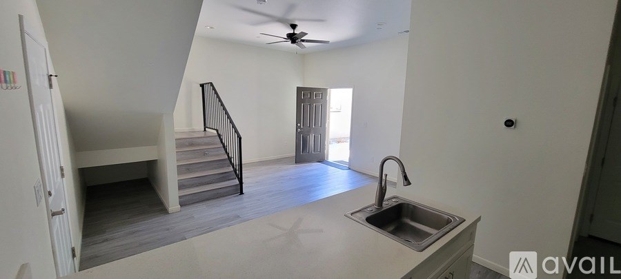 A kitchen with a sink and a staircase.