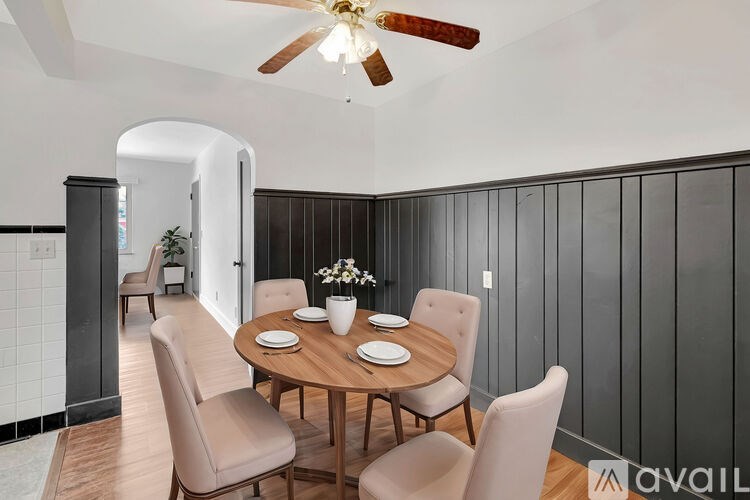 A dining room with a round table and chairs.