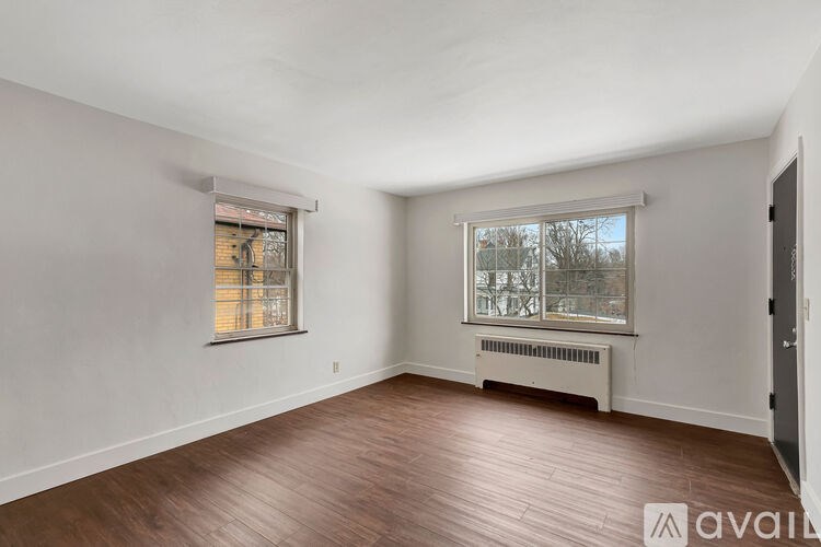 A room with wooden floors and two windows.