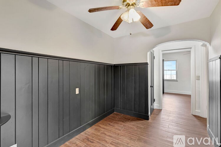 A room with wooden floors and a ceiling fan.