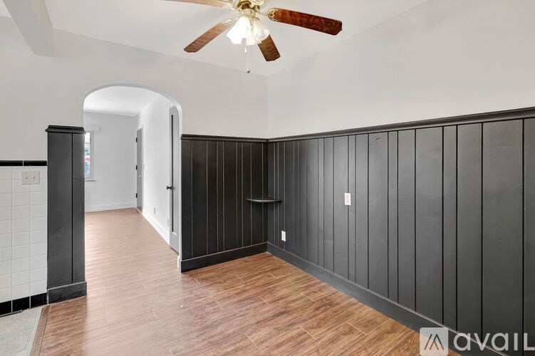 A room with a ceiling fan and wooden flooring.
