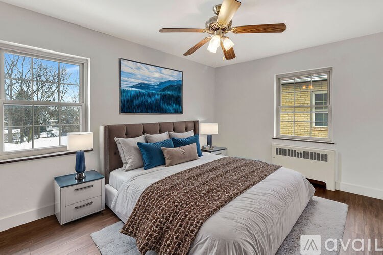 A bedroom with a large bed and a ceiling fan.