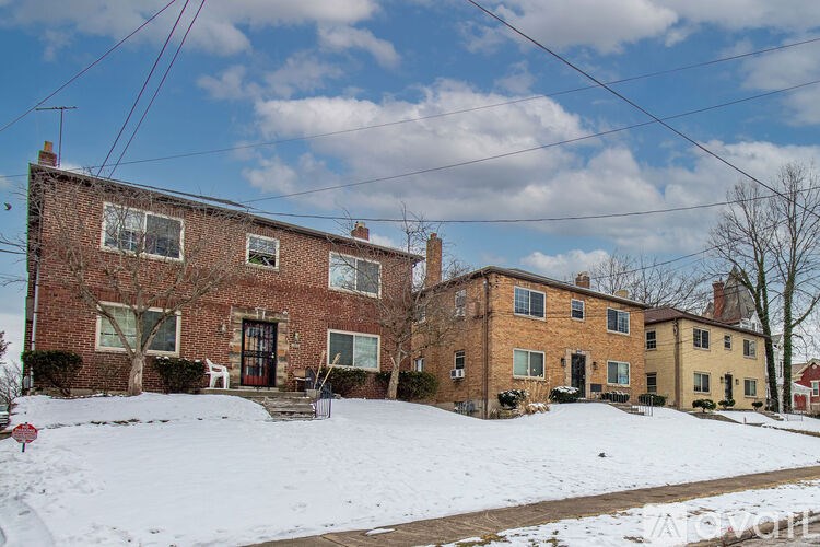 A red brick house with a white door and windows.