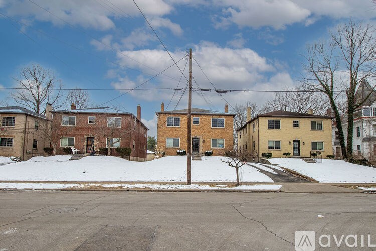 A row of houses with a tree in front of the yellow house.