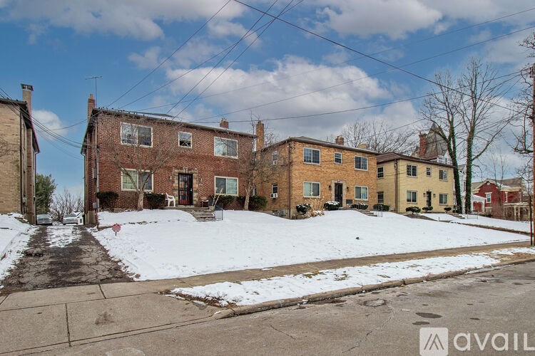 A row of houses with snow on the ground and bare trees.