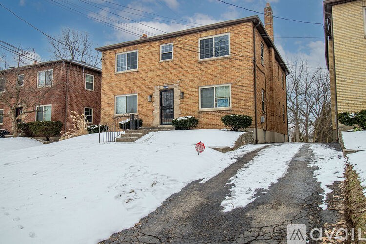 A red sign is on the side of a snow-covered road.