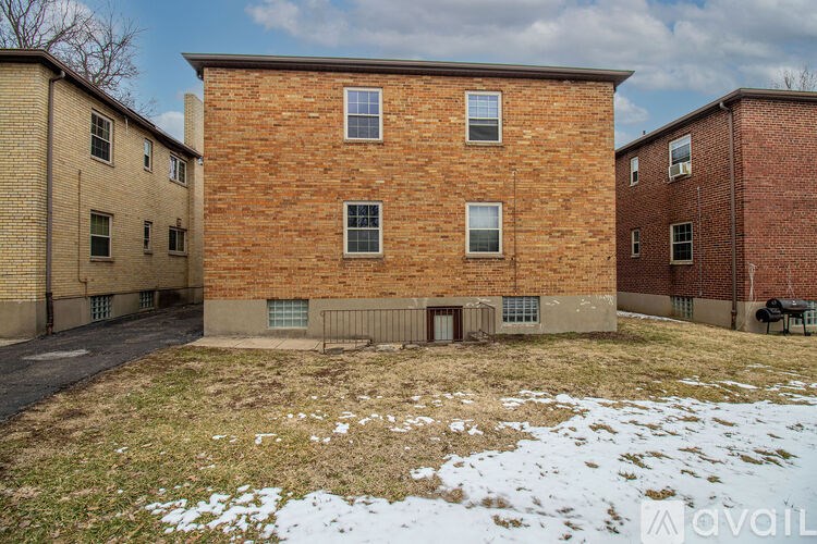 A red brick building with a small courtyard in front.