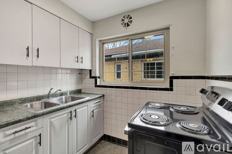 A kitchen with white cabinets and a black stove top.