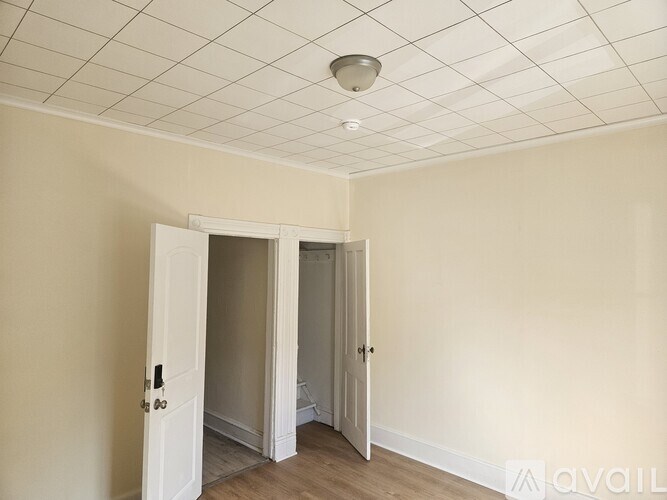 A room with a white ceiling and a doorway leading to another room.