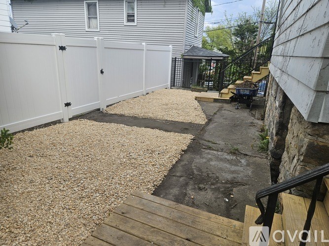 A backyard with a wooden deck and a gravel area.