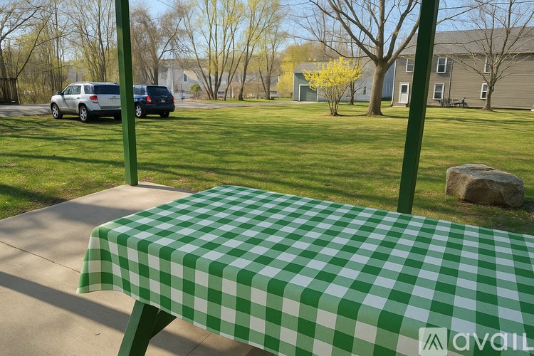 A picnic table with a green and white checkered tablecloth is set up on a concrete platform.