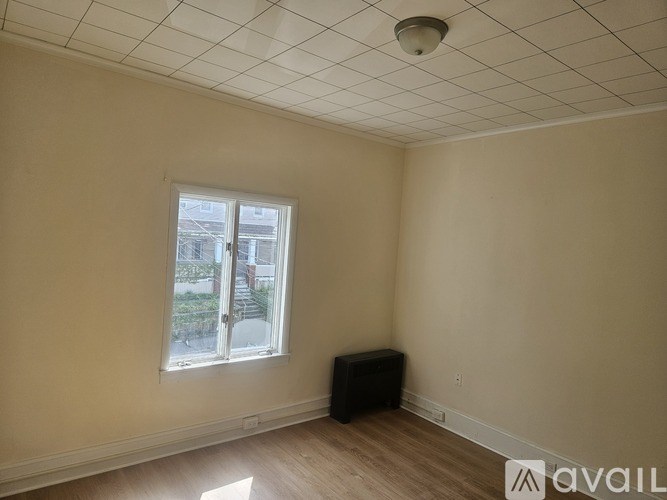 A room with a window and a speaker on the floor.