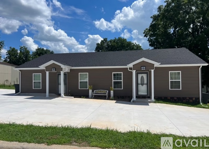A two-story house with a brown and beige exterior is available for purchase.
