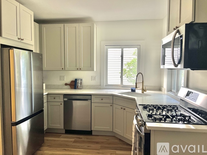 A kitchen with a stainless steel refrigerator and a stove top oven.