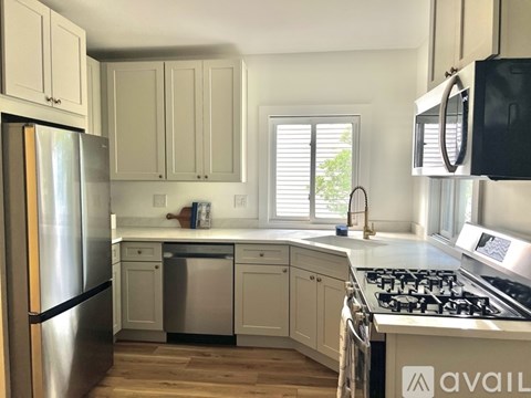 A kitchen with a stainless steel refrigerator and a stove top oven.