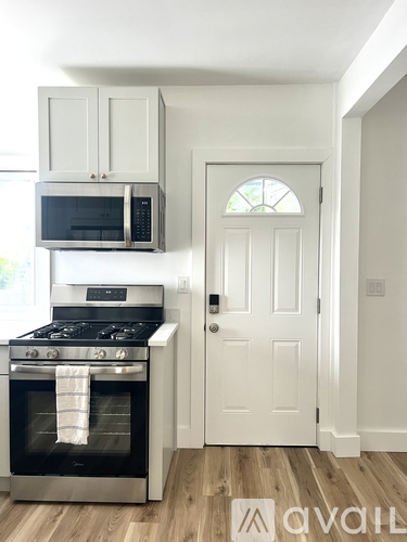 A kitchen with a stove, oven, microwave, and cabinets.