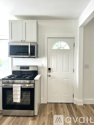 A kitchen with a stove, oven, microwave, and cabinets.