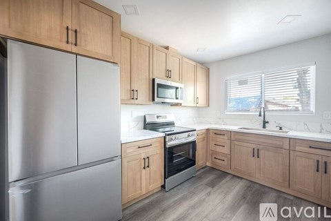 A kitchen with wooden cabinets and a stainless steel refrigerator.
