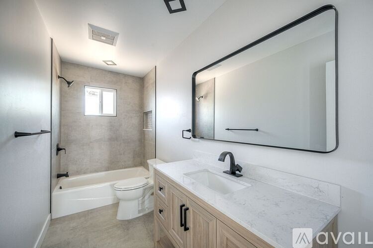A bathroom with a tub, toilet, and sink.