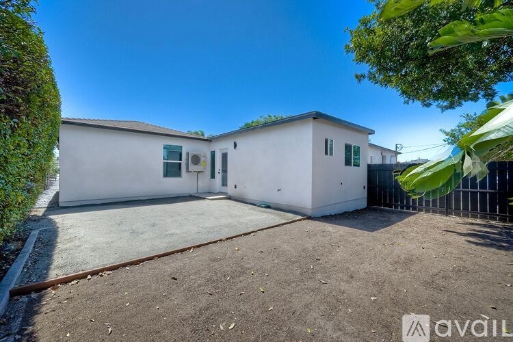 A white house with a green sign that says "available" in the foreground.