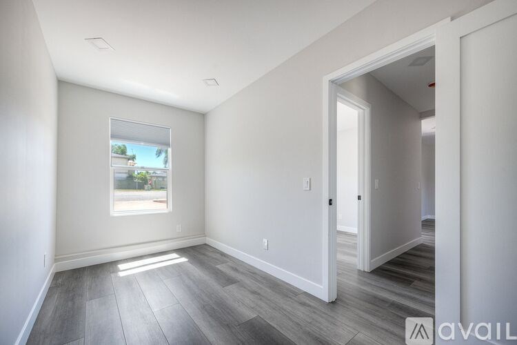 A room with a window and a door is available for rent.