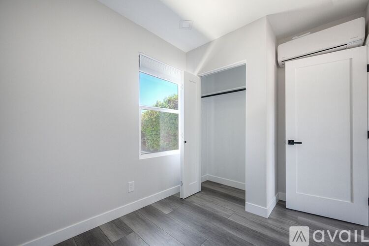 A room with a window and a door is available for rent.