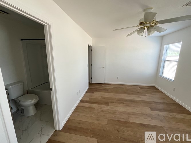 A room with a toilet and a fan.