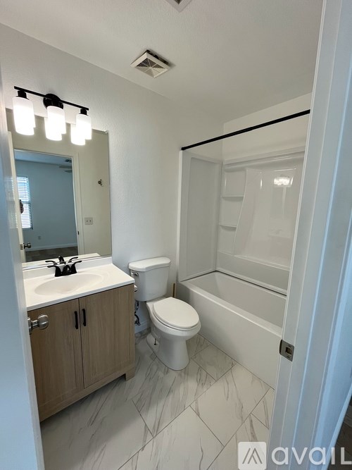 A bathroom with a toilet, sink, and mirror.