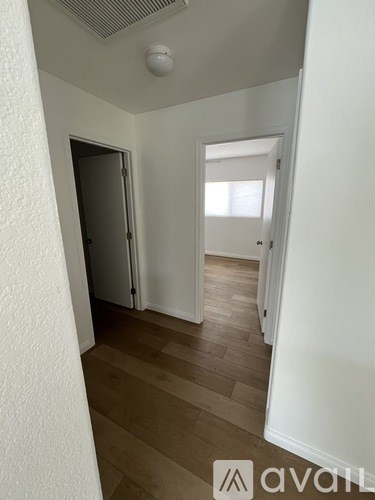 A hallway with a door on the left and a window on the right.