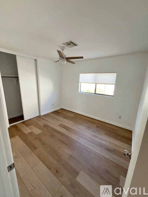 A room with wooden flooring and a ceiling fan.