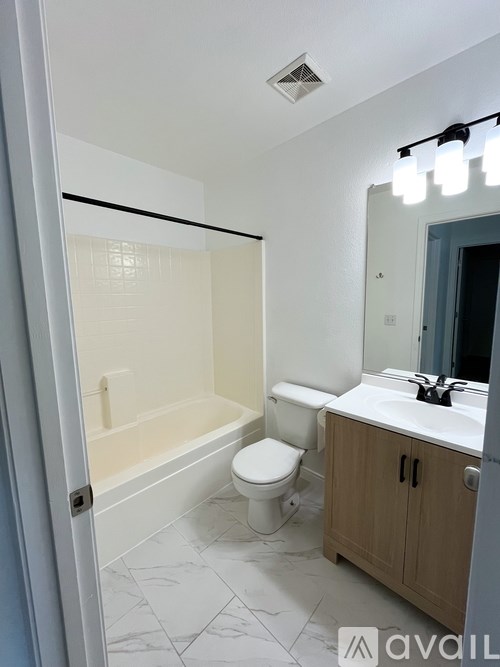 A bathroom with a toilet, sink, and bathtub.
