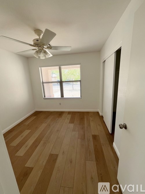 A room with wooden flooring and a ceiling fan.