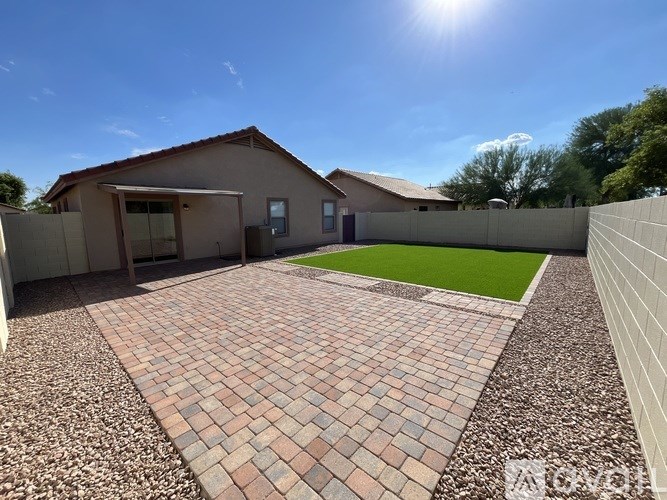 A house with a brick patio in front of it.