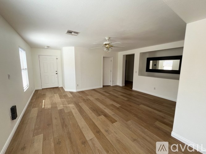 A room with wooden flooring and a ceiling fan.