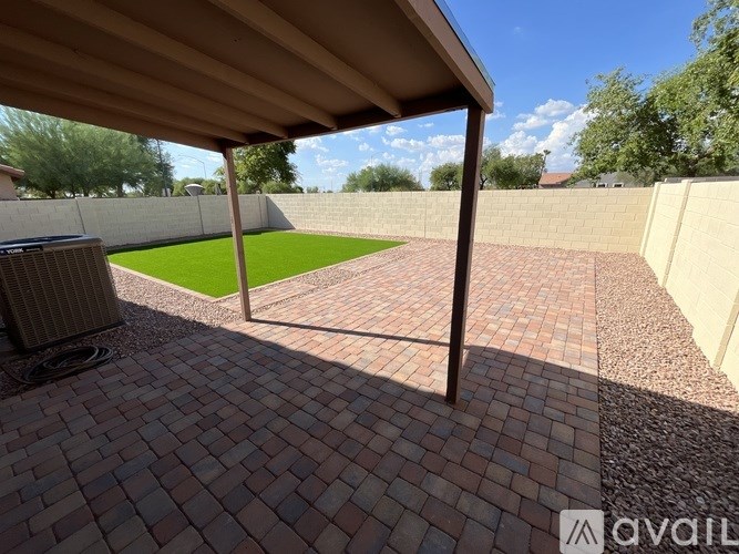 A patio with a brick floor and a wooden roof.