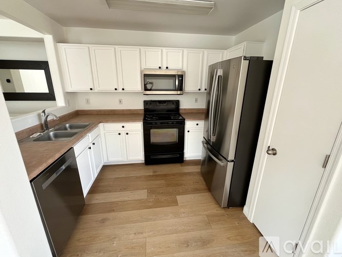 A kitchen with white cabinets and a black stove top oven.