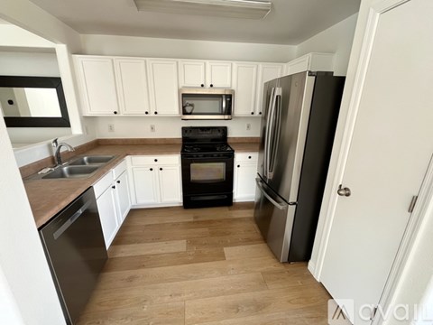 A kitchen with white cabinets and a black stove top oven.