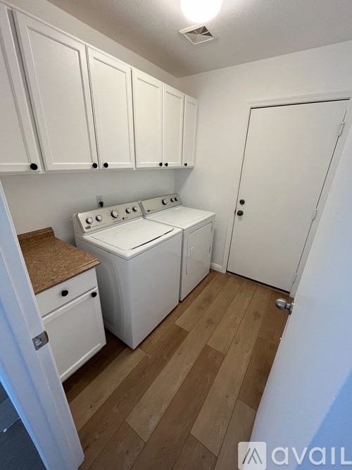A small kitchen with white cabinets and a white stove.