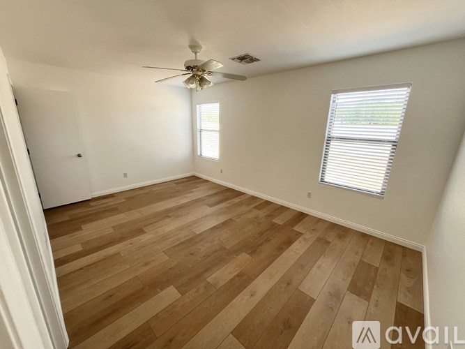 A room with wooden flooring and a ceiling fan.