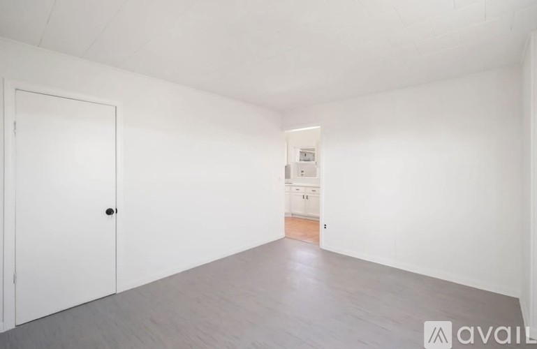A room with a white door and a white cabinet with a black handle.