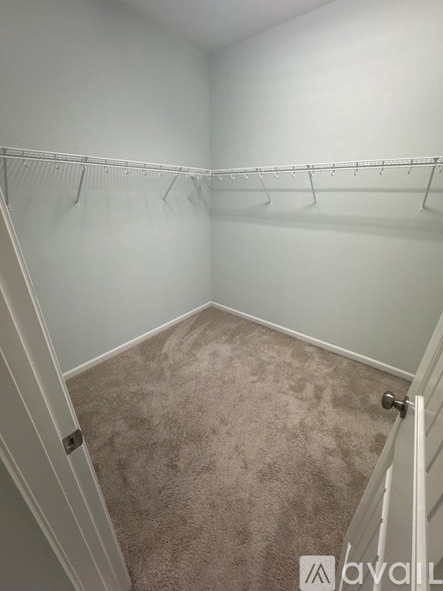 A room with a carpeted floor and a white door.