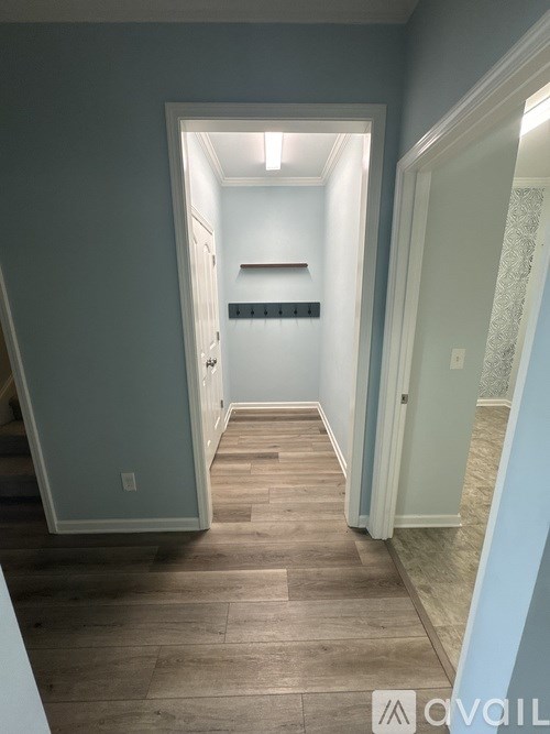 A hallway with a light on the ceiling and a wall on the left.