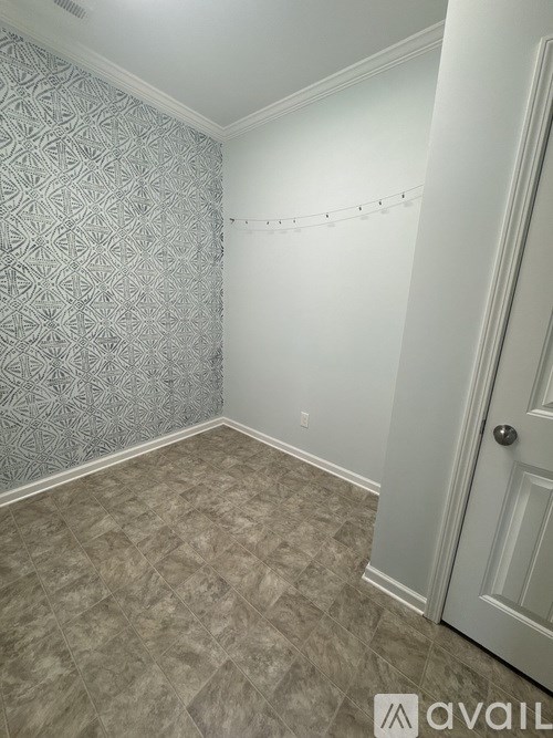 A room with a patterned wallpaper and a carpeted floor.